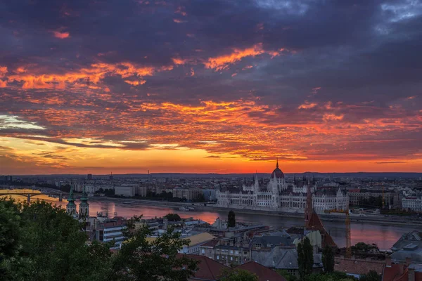 Budapest, Magyarország - drámai színes felhők és a napkelte felett Budapest és a magyar Parlament — Stock Fotó