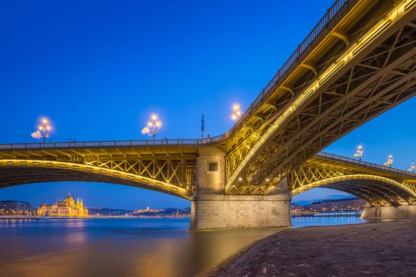 Budapeszt, Węgry - pięknie oświetlone Mostu Małgorzaty z Parlamentu Węgier o godzinę niebieski — Zdjęcie stockowe