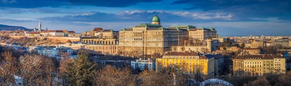 Budapešť, Maďarsko - Ultra široký panoramatický panorama pohled krásné Budínský hrad královský palác s parlamentem maďarské při západu slunce, modrá obloha a mraky — Stock fotografie