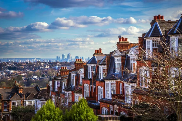 London, England - Panoramic skyline view of London and the skyscrapers of Canary Wharf with traditional British brick houses — Stock Photo, Image