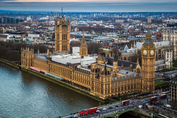 Londen, Engeland - luchtfoto skyline view van de beroemde Big Ben, Houses of Parliament, St Margaret Church en Westminster Bridge met rode dubbeldekker bussen bij zonsondergang — Stockfoto