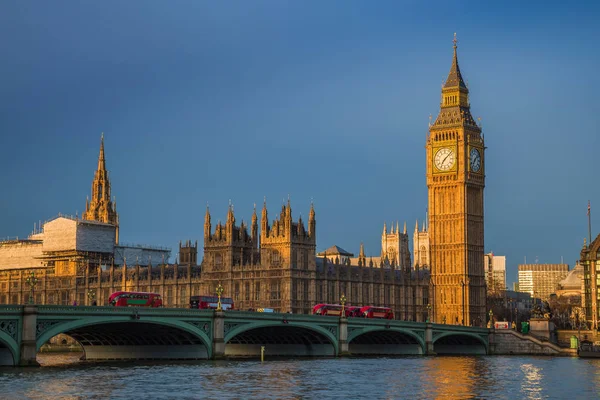 London, England - gyllene timmen tidigt på morgonen vid Big Ben, Houses of Parliament och ikoniska röda dubbeldäckare bussar på Westminster Bridge — Stockfoto