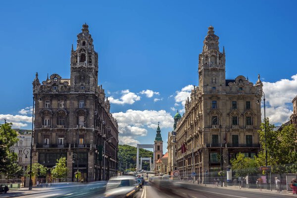 Budapest, Hungary - The beautiful Klotild and Matild Palace at Ferenciek Square, a neo baroque style twin palaces with Elisabeth Bridge and Gellert Hill at background. Heavy traffic in downtown Budapest