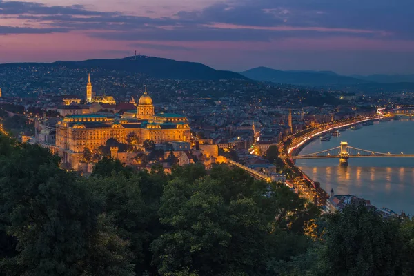 Budapest, Ungern - färgsprakande solnedgång på magiska timmen över Budapest med Buda Castle kungliga palatset och berömda Szechenyi Kedjebron — Stockfoto