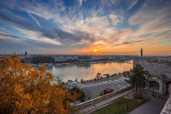 Budapest, Magyarország - színes őszi fák, a Budai vár gyönyörű felhők napkeltekor Budapest városára néző — Stock Fotó