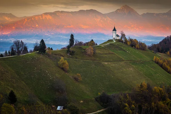 Jamnik, Slovenia - Beautiful golden sunset at Jamnik St. Primoz church. Julian Alps at background — Stock Photo, Image