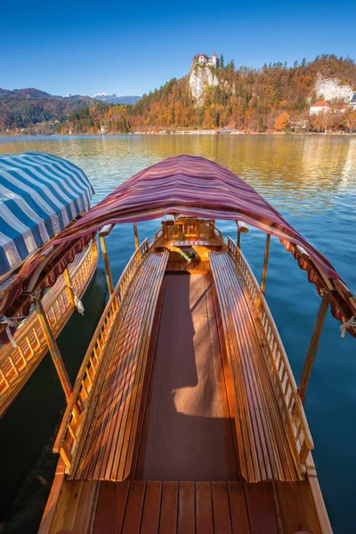 Bled, Slovenië - traditionele Sloveense pleatna boot bij Lake Bled (Blejsko jezero) met kasteel van Bled en de Julische Alpen op de achtergrond. Herfst landschap — Stockfoto