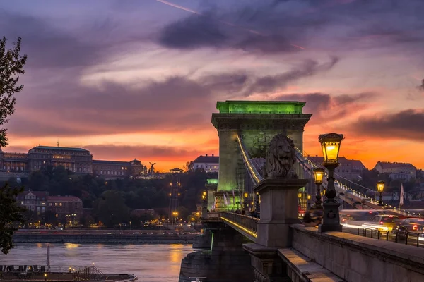 Budapest, Magyarország - drámai arany naplementét a Széchenyi Lánchíd zöld fények a Budavári királyi palota háttér — Stock Fotó