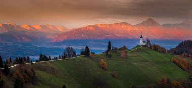Jamnik, Slovenya - Jamnik St. Primoz Kilisesi güzel altın gün batımı. Julian Alps, panoramik görüntü arka plan