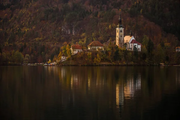 Μπλεντ, Σλοβενία - όμορφο φθινόπωρο σε Λίμνη Μπλεντ με την περίφημη εκκλησία προσκυνήματος της Κοιμήσεως Θεοτόκου της Μαρίας και Ιουλιανών Άλπεων στο παρασκήνιο — Φωτογραφία Αρχείου