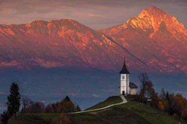 Jamnik, Slovenya - güzel altın günbatımında Jamnik St. Primoz kilisede Julian Alps ile arka planda altın güneş ışığı