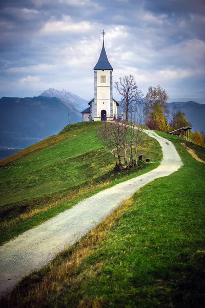 Jamnik, Slovenia - Красивая церковь Святого Примоза в Slovenia около Jamnik с Юлианскими Альпами на заднем плане — стоковое фото