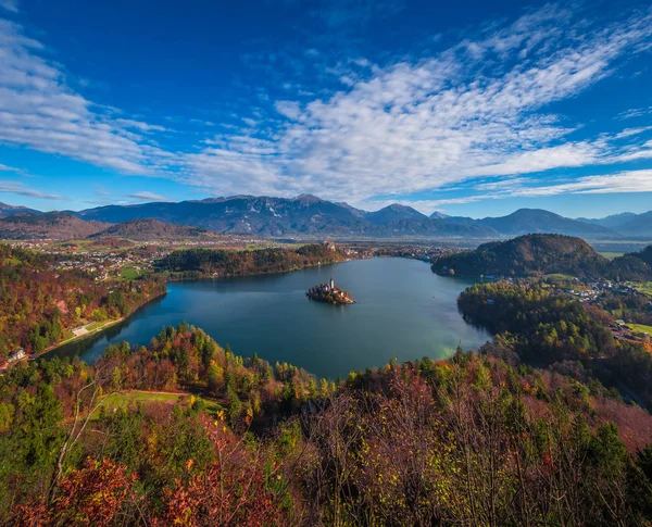 Bled, Slovinsko - panoramatické Panorama výhledem na jezera Bled převzata z Ojstrica hlediska s slavný poutní kostel Nanebevzetí Marie, tradiční Pletna lodí a bledský hrad na pozadí na podzim — Stock fotografie