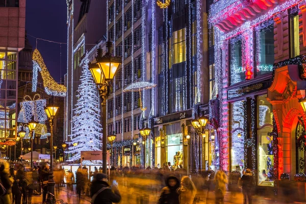 Budapest, Ungarn - 6. Dezember 2017: Touristenandrang auf der belebten Vaci-Straße, der berühmten Einkaufsstraße von Budapest zur Weihnachtszeit mit Geschäften, leuchtendem Weihnachtsbaum, Lichtern und Dekoration zur blauen Stunde — Stockfoto