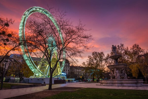 BUDAPEST, HUNGARY - DECEMBER 6, 2017: The famous Budapest Eye ferris wheel in Elisabeth park at Christmas time with beautiful colorful sky at sunset
