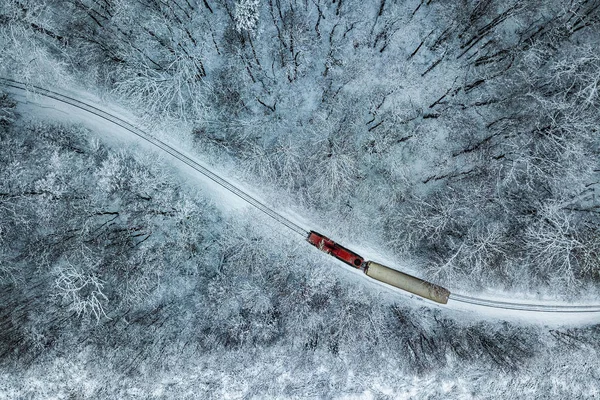 Bir dron Huvosvolgy yönü ile yukarıdan Budapest, Macaristan - kırmızı tren karlı ormanı havadan görünümü bir parça kış zamanında ele geçirdi