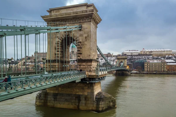 Budapesta, Ungaria - Podul cu lanț Szechenyi de renume mondial peste Dunăre cu Palatul Regal al Castelului Buda pe fundal într-o după-amiază de iarnă tulbure — Fotografie, imagine de stoc