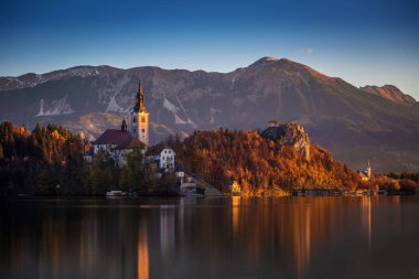 Bled, Slovenya - güzel Gölü sonbahar gündoğumu Maria varsayım Bled Kalesi ve Julian Alps ile ünlü hac Kilisesi ile arka plan Bled