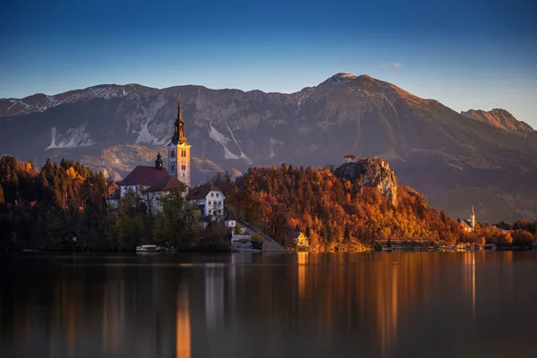 Bled, Eslovenia - Hermoso amanecer de otoño en el lago Bled con la famosa iglesia de peregrinación de la Asunción de María con el castillo de Bled y los Alpes Julianos en el fondo — Foto de Stock