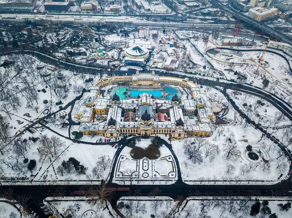 Budapest, Hongarije - luchtfoto van het beroemde Szechenyi thermale bad van bovenaf in het besneeuwde stadspark op wintertijd — Stockfoto