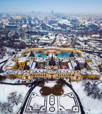 Budapest, Hungary - Aerial skyline view of the famous Szechenyi Thermal Bath in City Park (Varosliget) on a snowy winter morning clipart