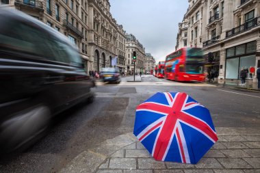 Londra, İngiltere - ikonik kırmızı Çift katlı otobüs ve hareket halinde siyah taksi ile meşgul Regent Street'teki İngiliz şemsiye