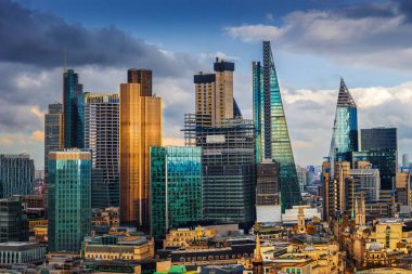 Londra, İngiltere - banka ve Canary Wharf, Londra'nın önde gelen finansal ilçeleri ile ünlü gökdelenler ve diğer yerler mavi gökyüzü ve bulutlar ile altın saat batımında panoramik manzarası görünümü