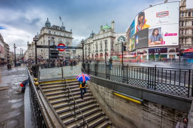 Londra - 15.03.2018: İngiliz şemsiye tutan ve Piccadilly metro istasyonu için aşağı gidiş Turist