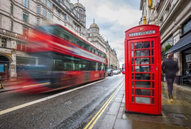 Londra, İngiltere - gündüz, geleneksel kırmızı telefon kulübesi Londra'nın merkezi ile yolda ikonik bulanık kırmızı Çift katlı otobüs