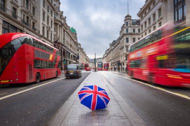 Londra, İngiltere - ikonik kırmızı Çift katlı otobüs ve hareket halinde siyah taksi ile meşgul Regent Street'teki İngiliz şemsiye