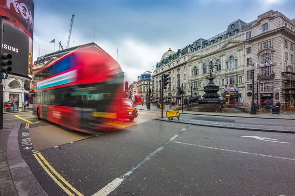 Londres, Inglaterra - 03.15.2018: tráfico ocupado en Piccadilly Circus con icónicos autobuses rojos de dos pisos en movimiento. Piccadilly Circus es el espacio público más famoso del West End de Londres —  Fotos de Stock