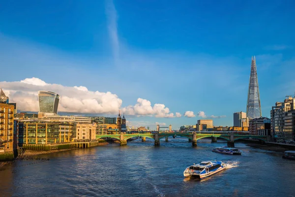 Лондон, Англия - экскурсионные лодки на закате на реке Тэймс с Саутворкским мостом и Тауэрским мостом и небоскребами на заднем плане — стоковое фото