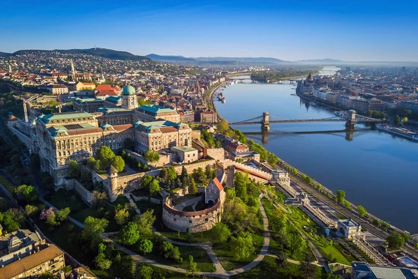 Будапешт, Венгрия - вид с высоты птичьего полета на королевский дворец Буда и южную Ронделлу на закате с Цепным мостом через Дунай, церковь и парламент Венгрии — стоковое фото