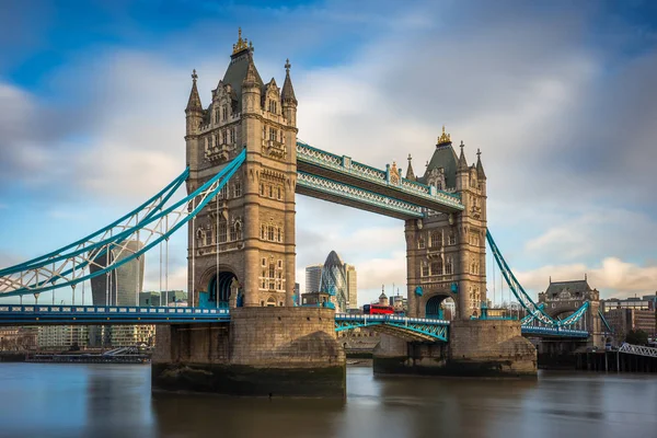 Londyn, Anglia - słynnego Tower Bridge z tradycyjny czerwony autobus piętrowy i drapaczy chmur w dzielnicy bankowej w tle — Zdjęcie stockowe