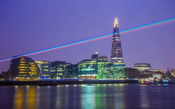 Londyn, Anglia - laserowe światła na niebie Londynu z wieżowiec Shard, statek krążownik Belfast i innych budynków biurowych o zmierzchu — Zdjęcie stockowe