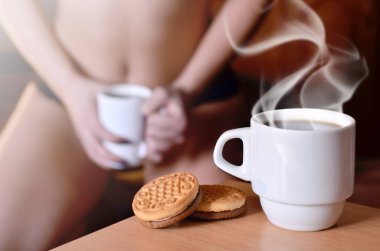 Erotik kahve molası. Kahve ve bisküvi ile seksi kız bulanık bir silüeti