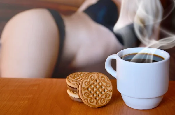 Erotic coffee break. Coffee and biscuits with a blurred silhouette of a sexy girl