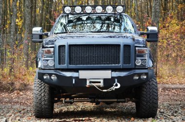 Sonbaharda yapraklar arasında SUV. Yere sonbahar yaprakları