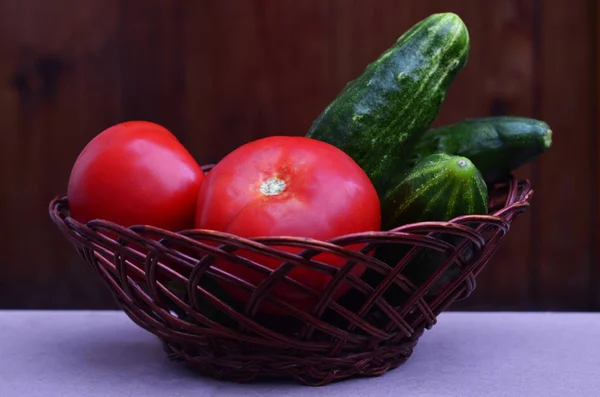 Basket with vegetables. Fresh and wet cucumbers and tomatoes