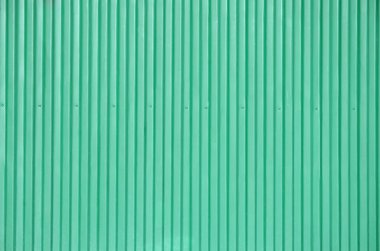 Dış cephe kaplaması, metal paneller closeup gündüz açık havada doku. Sac metal duvar veya çit kabartmalı. Arazi ve bir engel veya çit olarak büyük metal levha