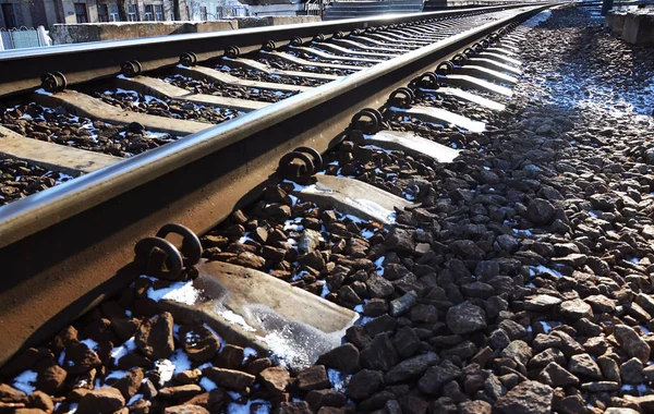 Details snowy Russian winter railway under bright sunlight. The rails and sleepers under the December snow. Russian Railways in detail