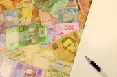 Ukrán bankjegyek rengeteg. Ukrán pénz kék toll és papír fehér üres lapot. A koncepció az ukrán gazdaság, számviteli és készpénz elszámolási. Ukrán nemzeti valuta