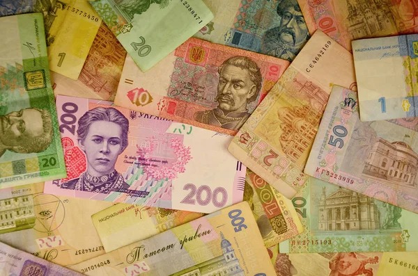 Many Ukrainian money bills of various denominations and colors. Ukrainian banknotes with portraits of historical and cultural figures and historical institutions. Modern Ukrainian money - hryvnia. UAH