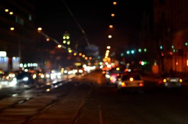 Gece ışıkları büyük şehir, bokeh trafik ışıkları ve yaklaşan araba farlar ile bulanık gece avenue.