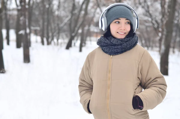 Winterporträt eines jungen Mädchens mit Kopfhörern — Stockfoto