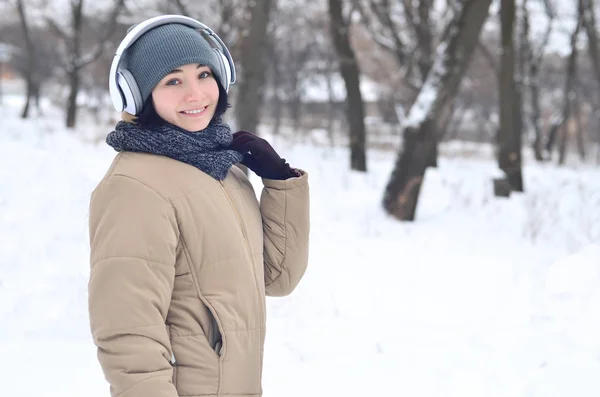 Vinter porträtt av ung flicka med hörlurar — Stockfoto