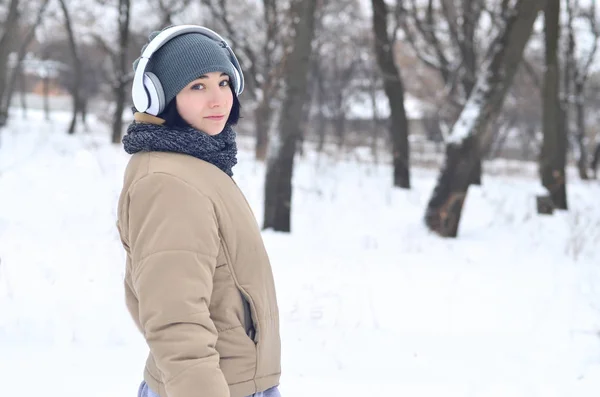 Winterporträt eines jungen Mädchens mit Kopfhörern — Stockfoto