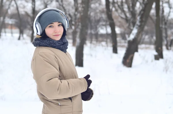 Winterporträt eines jungen Mädchens mit Kopfhörern — Stockfoto