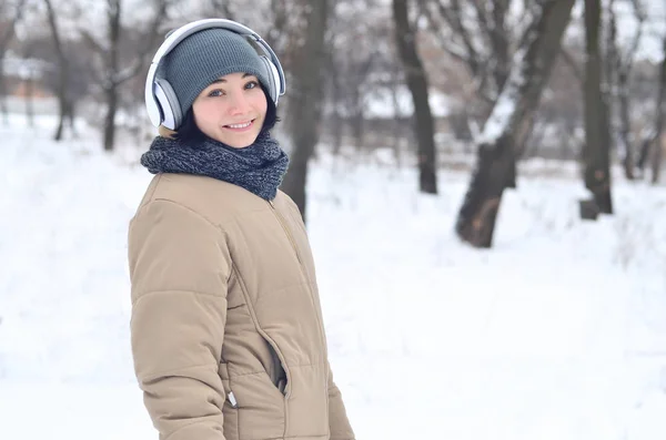 Winterporträt eines jungen Mädchens mit Kopfhörern — Stockfoto