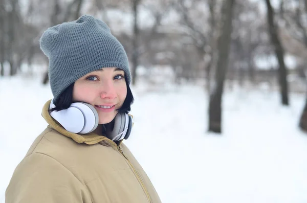 Winterporträt eines jungen Mädchens mit Kopfhörern — Stockfoto